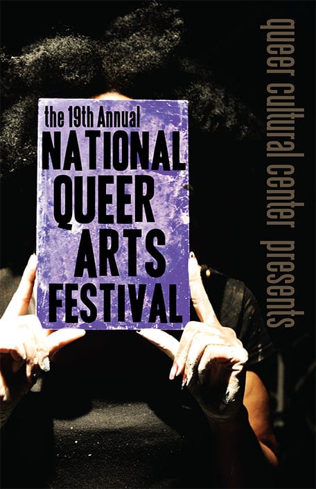 Person with black curly hair holding a sign in front of their faces that says the 19th annual national queer arts festival